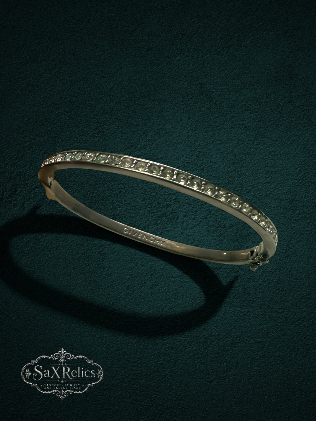 My Store vintage Givenchy silver-tone hinged bangle bracelet with sparkling clear crystals on a dark textured background