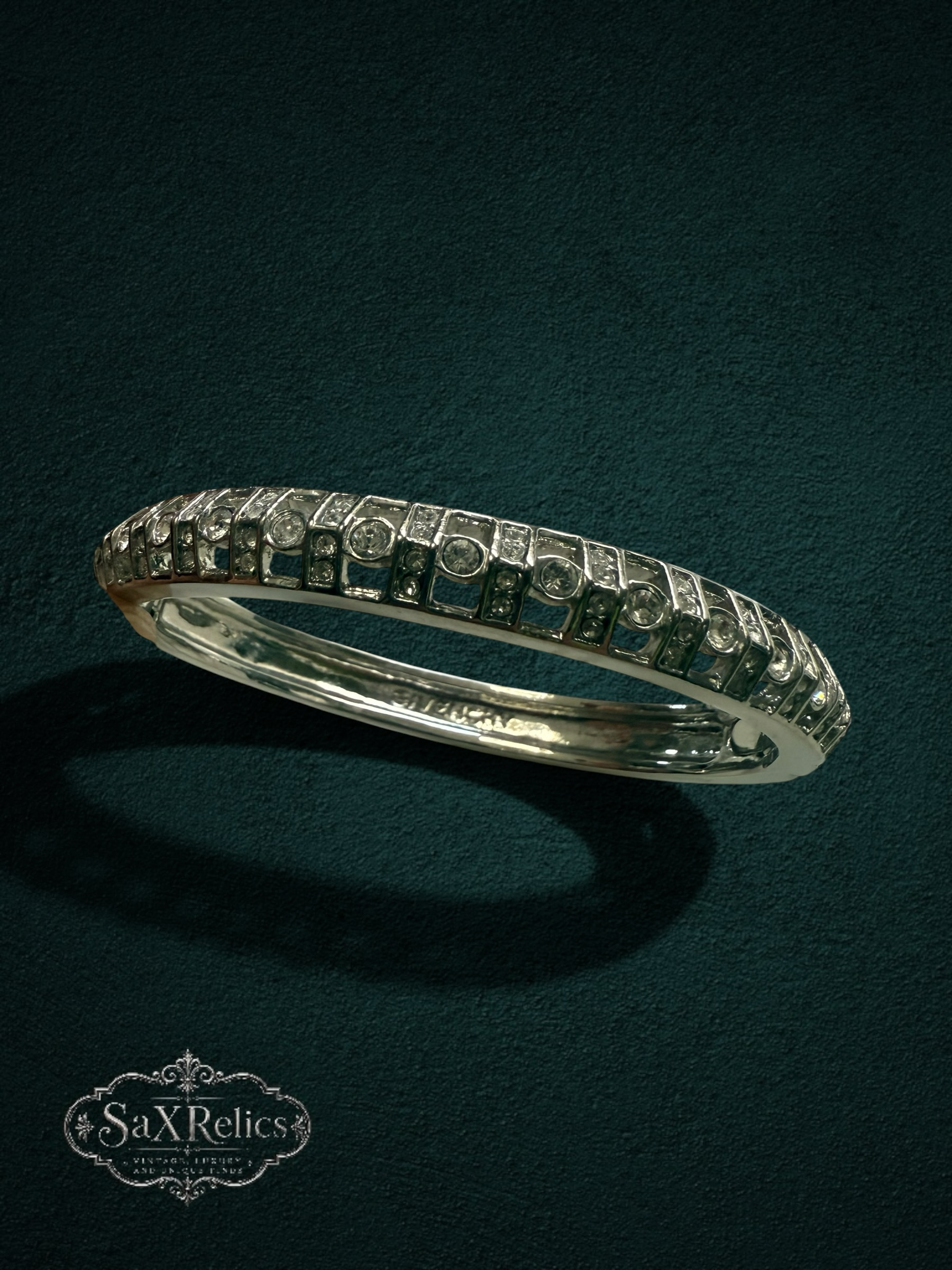 My Store vintage Givenchy silver-tone hinged bangle bracelet with sparkling clear crystals on a dark textured background