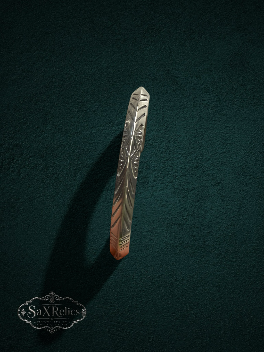 My Store handcrafted sterling silver cuff bracelet with intricate geometric engravings on a dark green background.