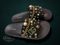 My Store Dolce & Gabbana black rubber slide sandals with pearl, gold stud, and chain embellishments. Features DG logo.