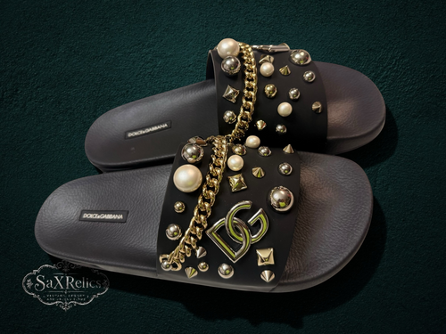 My Store Dolce & Gabbana black rubber slide sandals with pearl, gold stud, and chain embellishments. Features DG logo.