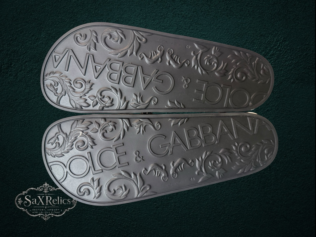 My Store Dolce & Gabbana black rubber slide sandals with embossed logo and ornate scrollwork on the sole.